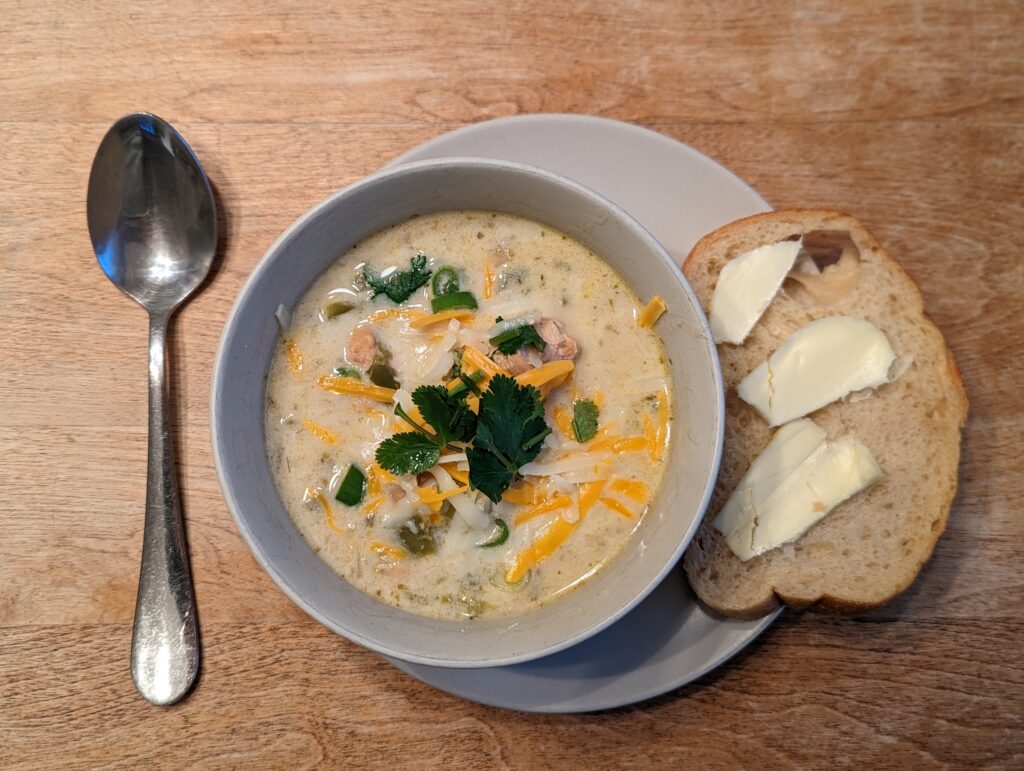 Bowl of finished White chicken chili with a side of buttered bread